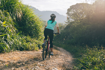 Fototapeta premium Woman cyclist riding a bike on a nature trail in the mountains.people living a healthy lifestyle