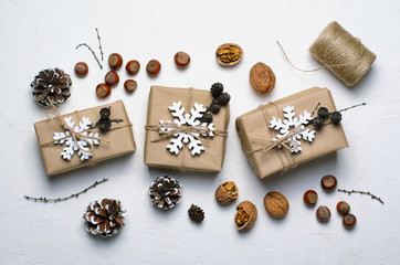 Fototapeta na wymiar Christmas Gifts, Nuts, Pine Cones on White Background, Nacural Decor Materials, Winter Holidays Concept