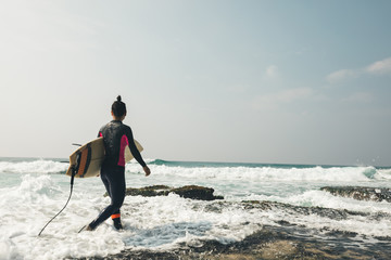 Woman surfer with surfboard going to surf