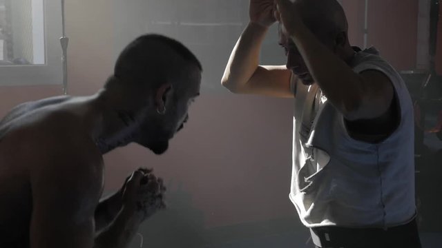 Rome, Italy,December 2018, coach training boxer punching in gym  slow motion closeup
