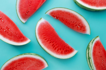Sliced watermelon on a blue background, creative summer concept, fruit flat lay