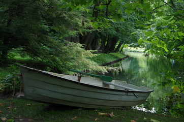 A boat at the pond in the park.
