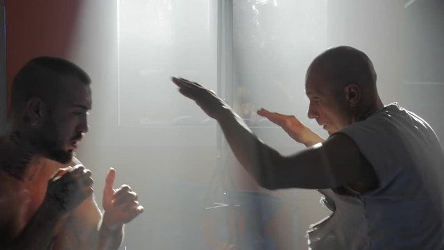 Rome, Italy,December 2018, coach training boxer punching in gym  slow motion medium shot