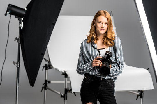 beautiful young female photographer working in professional photo studio