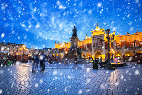 Fototapeta Old town of Krakow on a cold winter night with falling snow, Poland