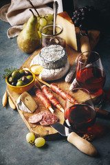Red wine with charcuterie assortment on the stone background