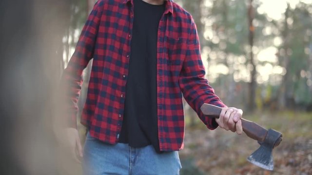 Man in the forest juggling with axe. Guy with an axe outdoors.
