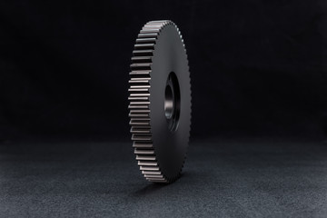 Plastic, black gear with 68 sprockets, isolated on a black background.