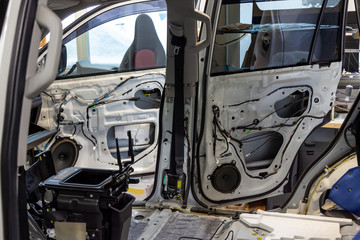 Disassembled body white crossover, removed the seat, side doors without panels, removed the cover from the mechanism of the passenger protection belt, exposed electric wires.