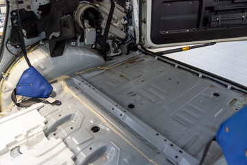 The back of the car in the back of an SUV without skin, prepared for repair and performance of noise insulation in a car tuning workshop.