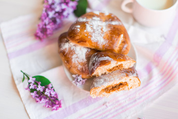 Delicious bakery cakes, buns with jam and violet flowers. Food and spring concept