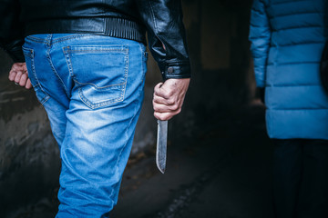 Unknown criminal guy with knife chasing young girl