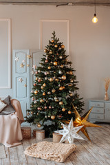 Bright cozy living room with a large elegant Christmas tree, decorated for Christmas