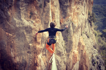 Highliner on a rope. Highline on a background of mountains. Extreme sport on the nature. Balancing...