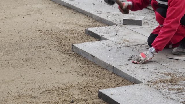 Workers make concrete tiles with Rubber hammer for paving paths