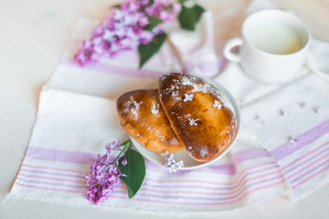 Delicious bakery cakes, buns with jam and violet flowers. Food and spring concept