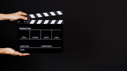 Fototapeta na wymiar Two Hand's holding Clapperboard or clap board or movie slate use in video production ,film, cinema industry on black background.