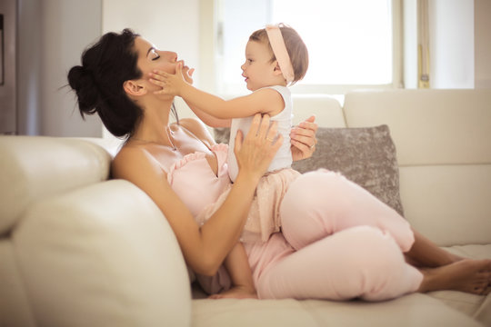 Mother and daughter playing on the sofa