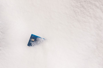 Credit card in the winter snow. Concept of freeze credit reports or accounts