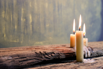 Candle on a old oak wooden table.  Beautiful gold background.Religion concept.