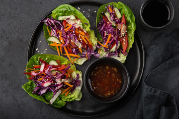 rainbow vegetarian lettuce wraps  on black plate