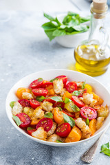 panzanella, traditional italian tomato and bread salad in white bowl