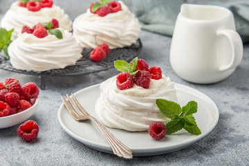 mini pavlova  meringue cakes with whipped cream and fresh raspberry