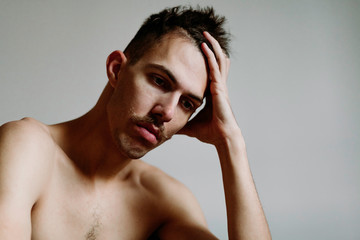 Fototapeta premium Young shirtless man with mustache thinking