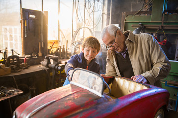 A grandfather and his grandson in the DIY workshop - Powered by Adobe