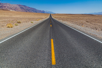 Death Valley road straight across the desert to the mountains in the distance