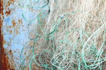 Old tangled fishing net on rusty blue metal background.