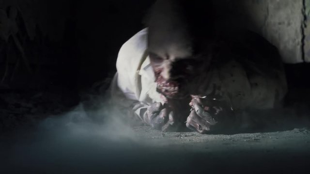 Horror scene of a scrambling, walking dead zombie scientist