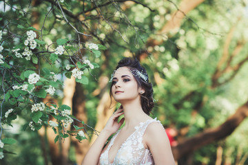 portrait of a beautiful bride in a wedding dress near a flower tree