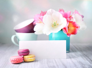 Holiday cardempty copy space blank.Flowers in vase,mug,macaroons on wooden table. Mother's day,women's day.