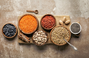 top view of wooden board with legumes, goji berries and healthy ingredients with rustic background