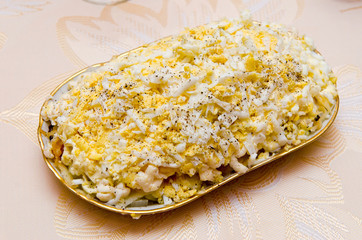 Salad with egg onions, meat and mayonnaise on a dish