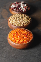 selective focus of lentils, soy and beans in wooden bowls on table