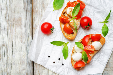 Caprese bruschetta with fresh tomatoes and Basil leaves