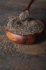 chia seeds in wooden bowl on table surface