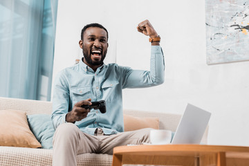 african american man rejoicing while playing video game