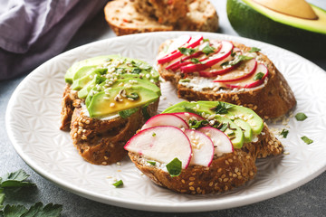 Cereal bread sandwiches with cottage cheese, fresh avocado and radish.