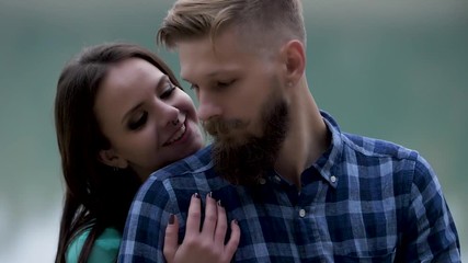 Loving wife is hugging husband shoulder by standing behind his back Tender fingers touch