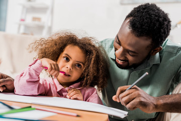 Obraz premium african american man drawing with daughter in living room
