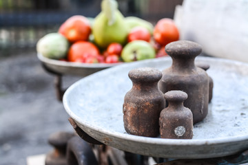 Old rusty scales weighting fruits and vegetables such as pears, tomatoes and cucumbers. country marketplace on warm autumn day, harvest festival