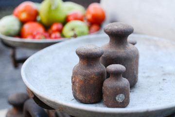 Old rusty scales weighting fruits and vegetables such as pears, tomatoes and cucumbers. country marketplace on warm autumn day, harvest festival