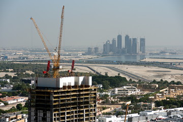 Fototapeta premium Aerial view of under construction building with cranes from downtown, visible whole Zabeel district, Dubai Creek harbor, Dubai Canal to Business Bay and Al Khail road