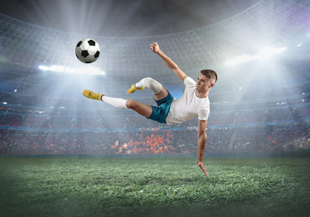 Fototapeta na wymiar Soccer player on a football field in dynamic action at summer day