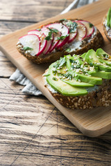 Cereal bread sandwiches with cottage cheese, fresh avocado and radish.