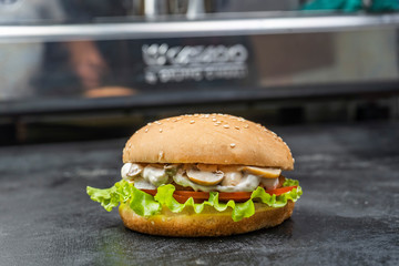 Classic burgers with becon, meat, cheese, onion, tomato and cheese and integral bun. On textured black board. Flat lay.