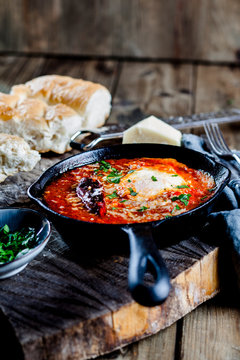 Eggs in Purgatory, eggs, baked in very spicy tomato sauce, sprinkled with parsley and parmigiana